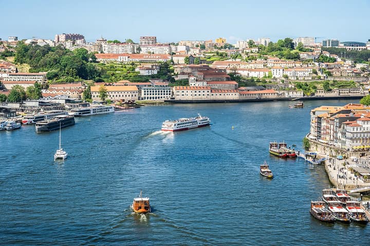 Porto — A scenic view of Porto, Portugal, showcasing the Douro River with various boats and the cityscape. (55245838307)
